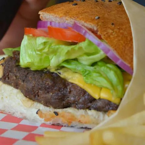 Hamburguesa clásica con queso amarillo, lechuga, tomate y cebolla