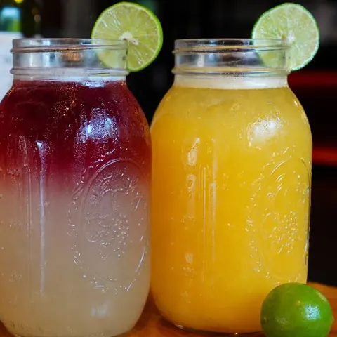 Limonada con vino tinto y limonada de mango en frascos
